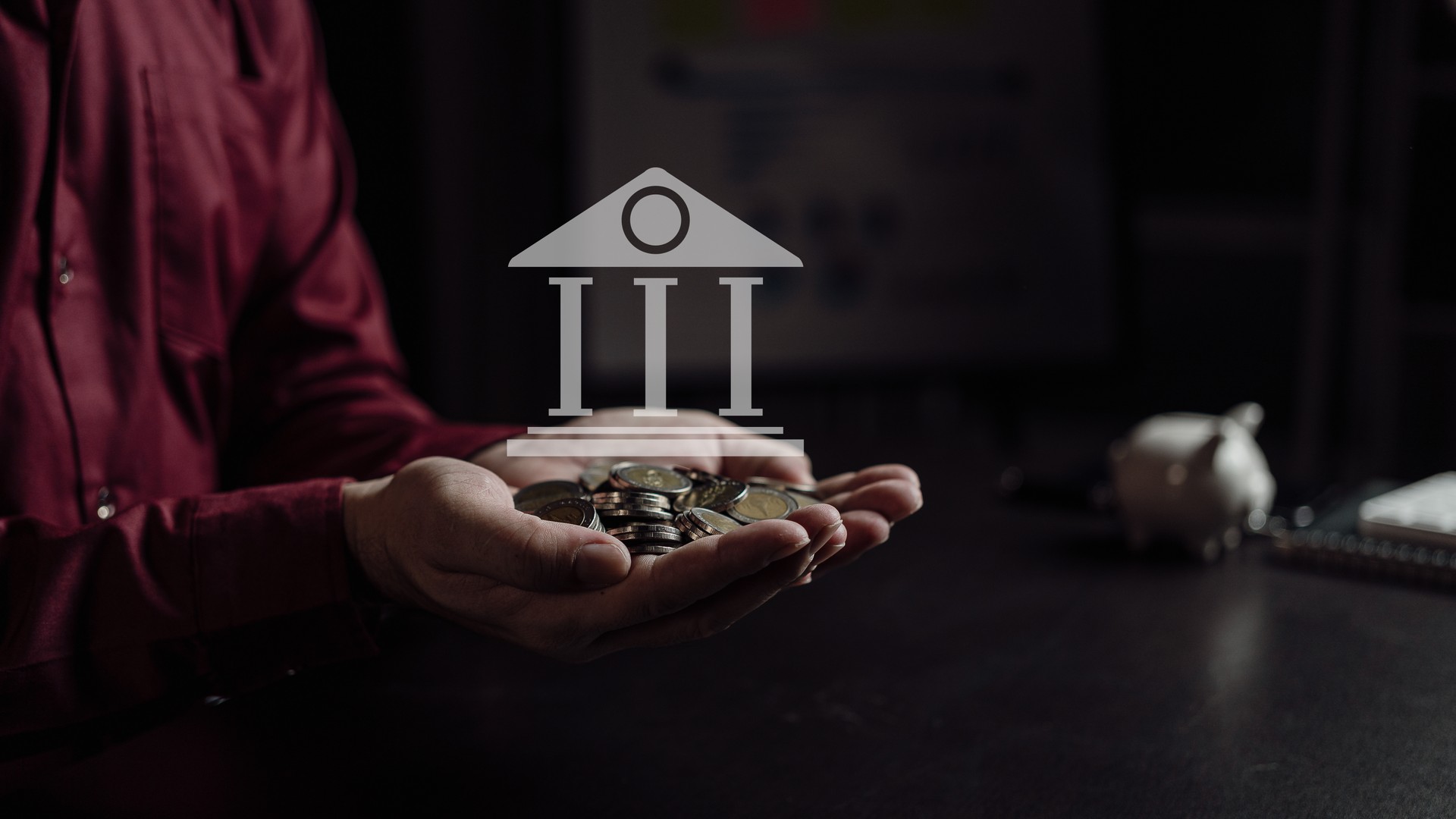 Close-up of businessman and coins stacked on hand with concept house icon. Finance of investment, real estate business, money saving concept